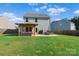 Large backyard featuring a patio, outdoor seating, and well-maintained lawn at 210 Clove Hitch Dr, Statesville, NC 28677
