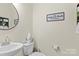 Powder room features modern fixtures, a round mirror, and toilet at 210 Clove Hitch Dr, Statesville, NC 28677