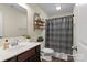 Neutral bathroom featuring a shower with curtain, open shelving, and sink at 210 Clove Hitch Dr, Statesville, NC 28677