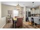 Stylish dining area featuring a modern light fixture, wood floors, and adjacent kitchen at 210 Clove Hitch Dr, Statesville, NC 28677