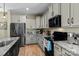 Stylish kitchen with white cabinets, granite counters, and stainless steel appliances at 210 Clove Hitch Dr, Statesville, NC 28677
