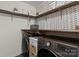 Functional laundry room with modern appliances and custom wooden shelving at 210 Clove Hitch Dr, Statesville, NC 28677