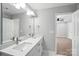 Bright bathroom featuring double vanity with quartz countertop and framed mirror at 2732 Mayfair Ave, Charlotte, NC 28208