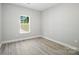 Bright bedroom with light gray walls, wood-look flooring and a window at 2732 Mayfair Ave, Charlotte, NC 28208