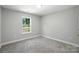 Neutral paint bedroom showcasing a window with greenery view and carpeted floor at 2732 Mayfair Ave, Charlotte, NC 28208