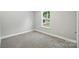 Bright bedroom with neutral walls, carpet and a window with an outside view at 2732 Mayfair Ave, Charlotte, NC 28208