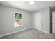 Bright, neutral paint bedroom, carpeted, and window showcasing greenery at 2732 Mayfair Ave, Charlotte, NC 28208