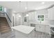 Kitchen island with stainless steel appliances, white cabinets, staircase, and natural light at 2732 Mayfair Ave, Charlotte, NC 28208