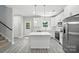 Stylish white kitchen with an island, stainless steel appliances, and pendant lighting creates a modern feel at 2732 Mayfair Ave, Charlotte, NC 28208
