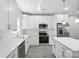 Bright, modern kitchen features white cabinets, stainless steel appliances, and a center island at 2732 Mayfair Ave, Charlotte, NC 28208