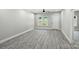 Spacious living room with modern ceiling fan, neutral paint, and wood-look flooring, leading to other rooms at 2732 Mayfair Ave, Charlotte, NC 28208