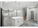 Open-concept living space with a kitchen island, gray wood floors, and staircase at 2732 Mayfair Ave, Charlotte, NC 28208