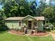 Charming green cottage-style home with a cozy front porch and landscaped garden beds at 302 Margarette Ave, Belmont, NC 28012