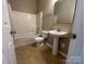Bathroom featuring a shower-tub combo and pedestal sink at 3022 Hendricks Chapel Ln, Charlotte, NC 28216