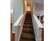 Carpeted staircase with white railing leads to the upper level, with views of the living spaces at 3022 Hendricks Chapel Ln, Charlotte, NC 28216