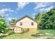 Backyard featuring back deck, shed, lush landscaping, and bright sunlight at 4124 Oakwood Rd, Charlotte, NC 28269