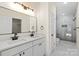 Bathroom with double sink vanity, modern lighting, white-tiled floors and shower stall at 5328 Oaktree Dr, Gastonia, NC 28052