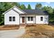 Charming single-story home features a white exterior, brick foundation, and a welcoming front porch at 5328 Oaktree Dr, Gastonia, NC 28052
