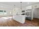 Open-concept living space with a kitchen featuring an island and stainless steel appliances and backyard access at 5328 Oaktree Dr, Gastonia, NC 28052
