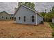 Back exterior showcasing light blue siding, windows, and an AC unit, set in newly seeded yard at 651 S Elm St # 2, Statesville, NC 28677