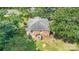 Aerial view of backyard with mature trees and a cozy single-Gathering house featuring a brick exterior and a well-maintained yard at 6616 Woodlawn Ln, Indian Trail, NC 28079
