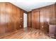 Bedroom with wood paneled walls, hardwood floors, and two doors at 6616 Woodlawn Ln, Indian Trail, NC 28079