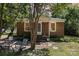 Charming brick home featuring a cozy porch, mature trees, and a well-maintained front yard at 6616 Woodlawn Ln, Indian Trail, NC 28079