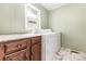 Functional laundry area featuring a modern washer and dryer, plus wood storage cabinets at 6616 Woodlawn Ln, Indian Trail, NC 28079