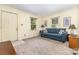 Bright living room with a comfortable blue sofa, multiple windows, and neutral colored walls at 6616 Woodlawn Ln, Indian Trail, NC 28079