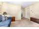 Living room featuring neutral walls and carpet flooring along with storage and comfortable blue sofa at 6616 Woodlawn Ln, Indian Trail, NC 28079