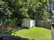 Backyard storage shed surrounded by lush greenery and a privacy fence, perfect for storing tools and equipment at 707 Regency Dr, Charlotte, NC 28211