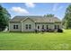 Spacious backyard with a large patio, outdoor furniture, and a lush green lawn at 8275 Normandy Rd, Denver, NC 28037