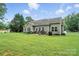 Expansive backyard featuring a patio area, green lawn, and mature trees, perfect for outdoor enjoyment at 8275 Normandy Rd, Denver, NC 28037