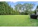 Well-maintained backyard with a lush lawn and mature trees, creating a private and serene space at 8275 Normandy Rd, Denver, NC 28037