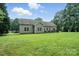 Home's backyard with well-manicured lawn, patio seating, and mature trees at 8275 Normandy Rd, Denver, NC 28037