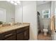 Granite countertop vanity in a well lit bathroom with a window and dark wood cabinets at 8275 Normandy Rd, Denver, NC 28037