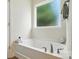 A luxurious soaking tub sits beneath a bright window in this well-appointed bathroom at 8275 Normandy Rd, Denver, NC 28037