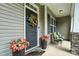 Inviting front porch with decorative flower pots, a welcome mat, and cozy seating, enhancing curb appeal at 8275 Normandy Rd, Denver, NC 28037