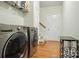 Well-equipped laundry room featuring modern washer and dryer units with hardwood floors at 8275 Normandy Rd, Denver, NC 28037