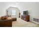 Cozy living room featuring a plush sofa, media center, and natural light from the window at 8275 Normandy Rd, Denver, NC 28037