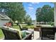Comfortable patio area with seating, a brick fire pit, and scenic backyard views at 8275 Normandy Rd, Denver, NC 28037