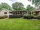 A nice home exterior featuring a screened porch, backyard, lush green lawn, and landscaping at 1047 Honeybee Trl, Fort Mill, SC 29715