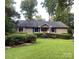 Inviting one-story home with a lush front lawn and meticulously trimmed hedges at 1047 Honeybee Trl, Fort Mill, SC 29715
