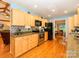 Modern kitchen boasts hardwood floors, light wood cabinets, granite countertops, and stainless steel appliances at 1047 Honeybee Trl, Fort Mill, SC 29715