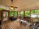 This screened porch has wooden floors, wicker furniture, and a ceiling fan for a relaxing atmosphere at 1047 Honeybee Trl, Fort Mill, SC 29715