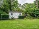 A well-kept storage shed in the backyard, surrounded by lush greenery and mature trees at 1047 Honeybee Trl, Fort Mill, SC 29715
