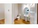 Bright half-bathroom with hardwood floors, toilet, pedestal sink, and an oval mirror at 11017 Warfield Ave # 4, Huntersville, NC 28078