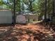 View of backyard with trees and shed with some personal items in the yard at 111/113 Shawnee Trl # D140/141, Mount Gilead, NC 27306