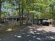 View of home with gravel driveway and mature trees at 111/113 Shawnee Trl # D140/141, Mount Gilead, NC 27306