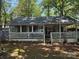 Charming home featuring a screened-in porch with a wooden deck and lush green surroundings at 111/113 Shawnee Trl # D140/141, Mount Gilead, NC 27306